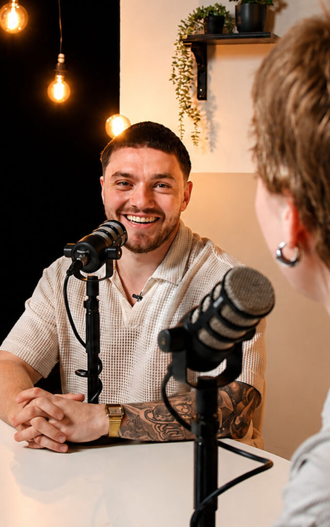 Professionele podcast productie met camera en lichtopstelling in een volledig ingerichte studio